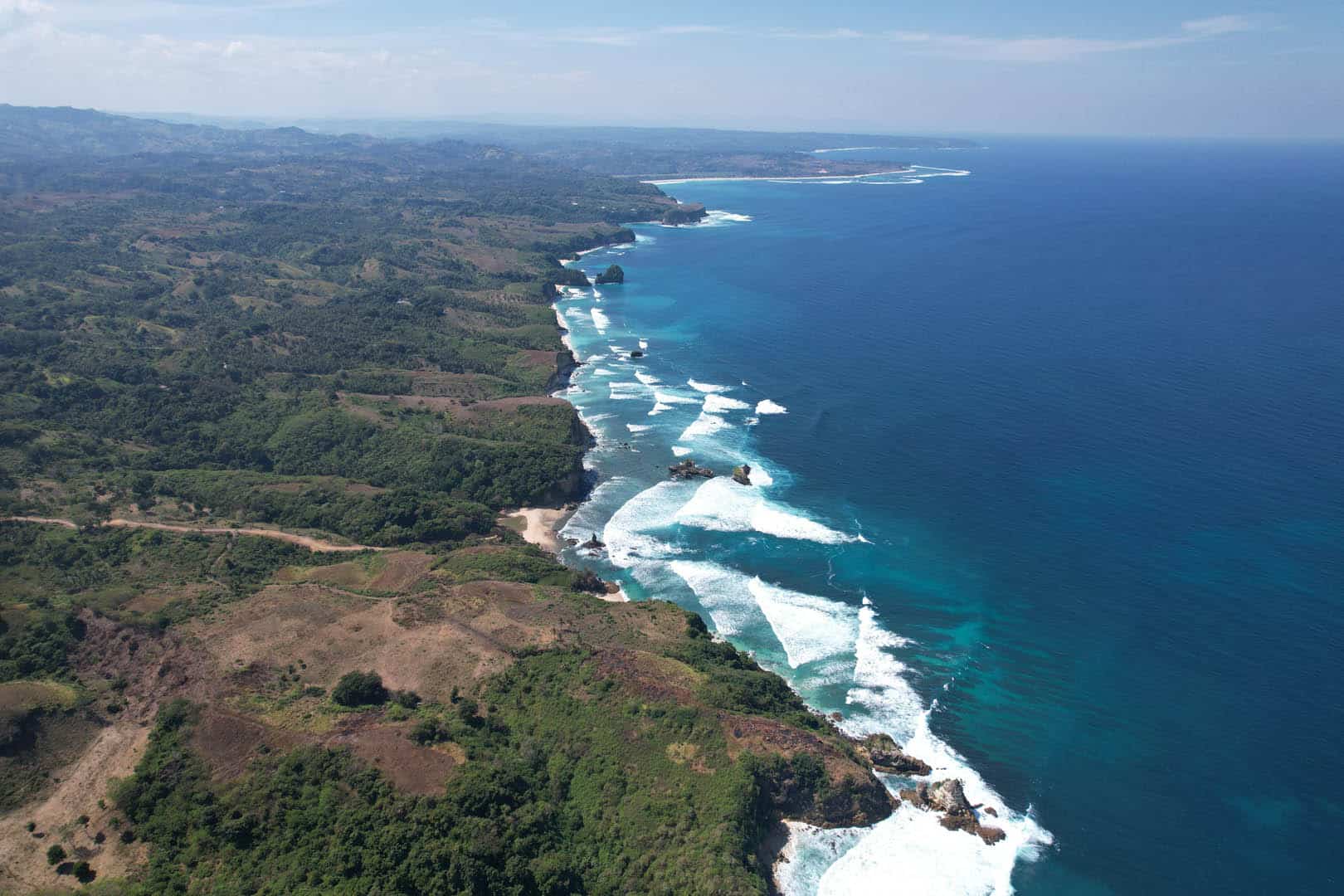 Dramatic coastline of Kabisu land with turquoise waves, hidden coves, and untouched beaches
