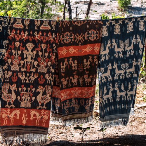 Sumba ikat cloths with horse and ancestor motifs hanging to dry outdoors.